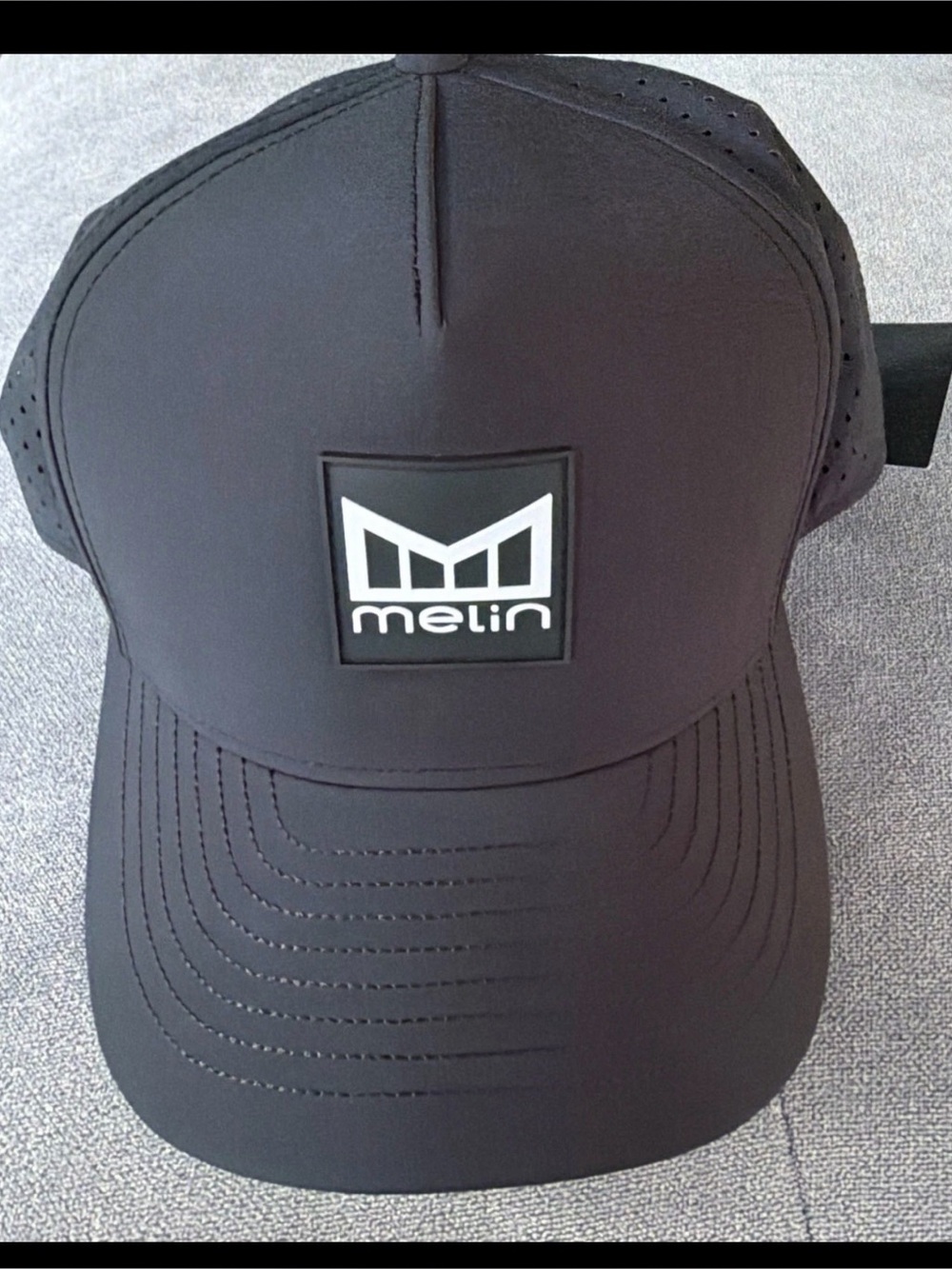 Melin Black Logo Trucker Hat